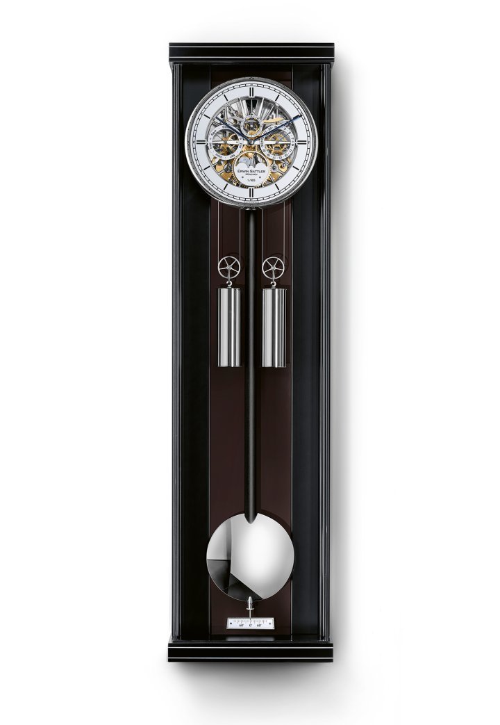 Erwin Sattler – Aperia III: The wall clock makes its elegant entrance into the contemporary home courtesy of Erwin Sattler, a storied manufacturer established in Munich. The Aperia III captures the attention for the multiple layers of its movement and for its dial composed of five skeletonised subdials. The enlightened amateur will notice the craftsmanship revealed by the fine guilloché work and by the hand-finishing of the components. Hand-painted moon phases complete the calendar display showing date and day. A repeater mechanism strikes the half-hour and can be silenced on demand. This superb clock has a power reserve of 30 days and is produced as a limited edition of 65 pieces. $$$