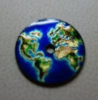 A tiny cloisonné enamel dial featuring a world map