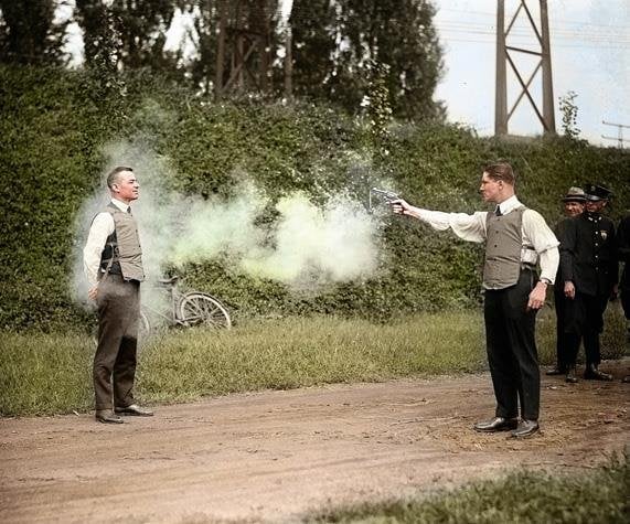 The deputy firing a .38 caliber revolver straight at his chest. (National Photo Company Collection/Library of Congress, Washington, D.C. | colored version: zuzahin)
