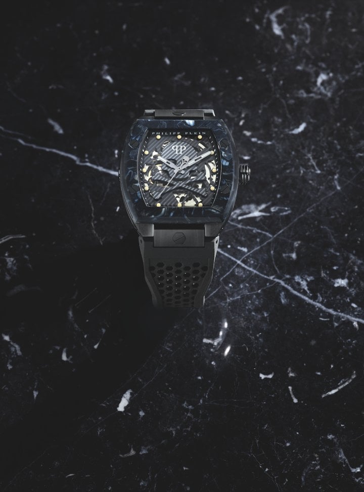 This timepiece is inspired by the $keleton sneakers collection. Punctuated by hexagonal screws, the top ring is embellished with carbon fibre effect or a setting of multicoloured baguette crystals, echoed in the indexes.
