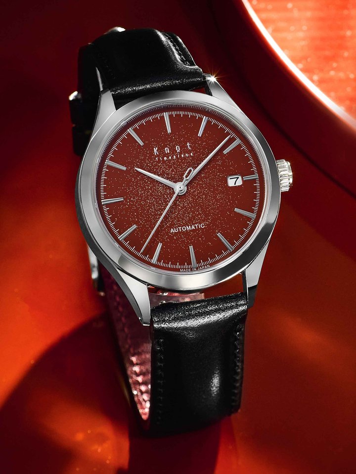 The traditionally vermilion red urushi dial sprinkled with gold and silver