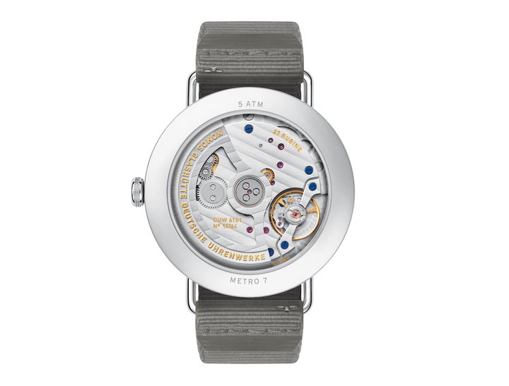 DUW 6101, the date calibre of the new Metro Update. The engraving on the rotor is embossed and gold-plated; the quick-set date functions both forward and backward.