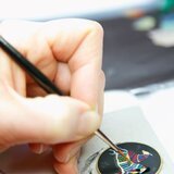 An artisan applies the layers of lacquer (pigments mixed with a copal-based varnish)