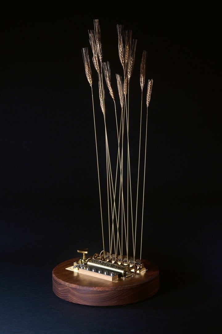 “Slightly Windy” music box. Twelve gilt ears of wheat sway in the wind to the sound of music (a selection of tunes is available). Circular base in ash, soundboard in walnut with a tulip tree veneer to provide strength and tension. This is a genuine musical instrument, expertly designed to produce the best possible sound. 