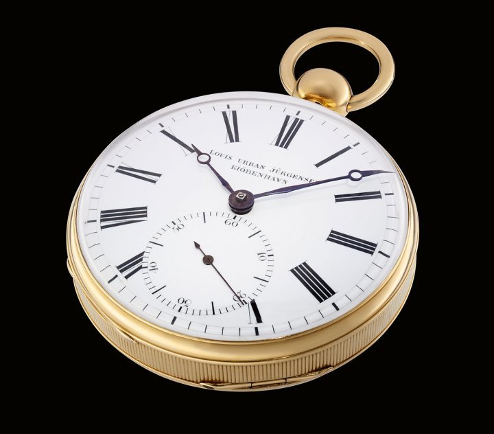 Louis Urban Jürgensen – no. 64 (1840s). Dial: White enamel with bold black Roman numerals. Separate seconds dial with Arabic numerals at 6 o'clock. Blued Breguet hands. The dial is signed “Louis Urban Jürgensen Kiöbenhavn”. This watch features an early stop-second function: on opening the bezel, a small lever is revealed. When turned to the stop position, a thin steel wire stops the balance (and thus the watch). This is a very useful feature for making observations and for setting the watch to the exact second.