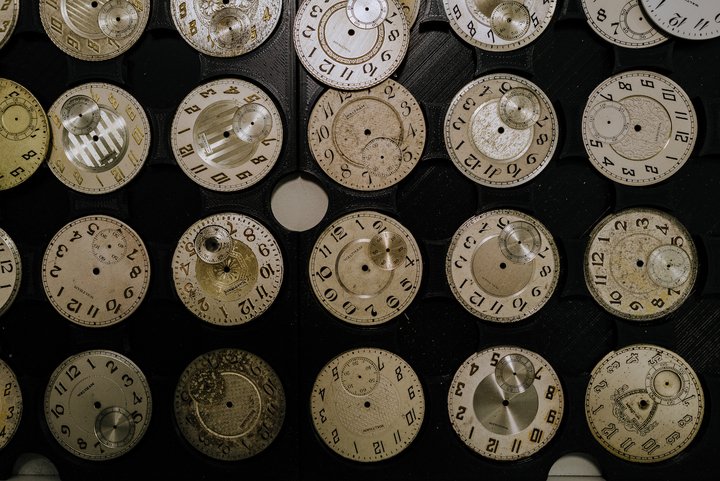 Assorted vintage pocket watch dials prepared for upcycling.