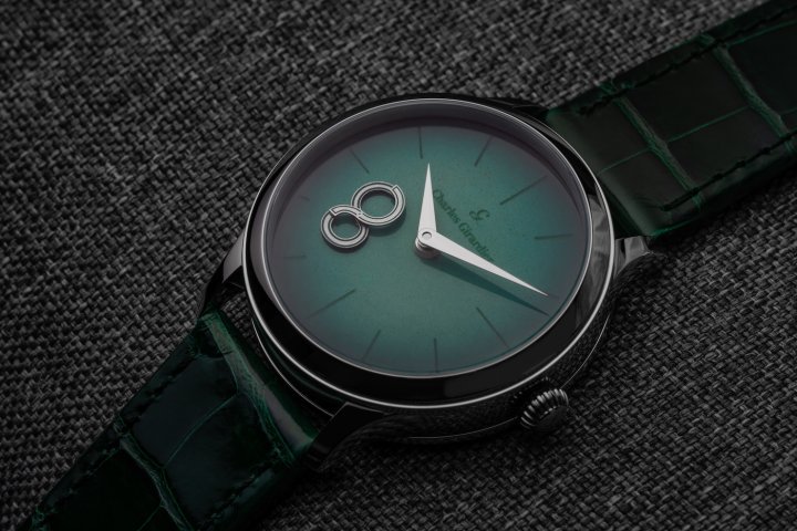 The Magic 8 model in grade-5 titanium featuring an emerald-green dial with colour gradation in grand feu enamel. Two asymmetrical hands continuously form and reform the figure 8, denoting infinity and perpetual movement.