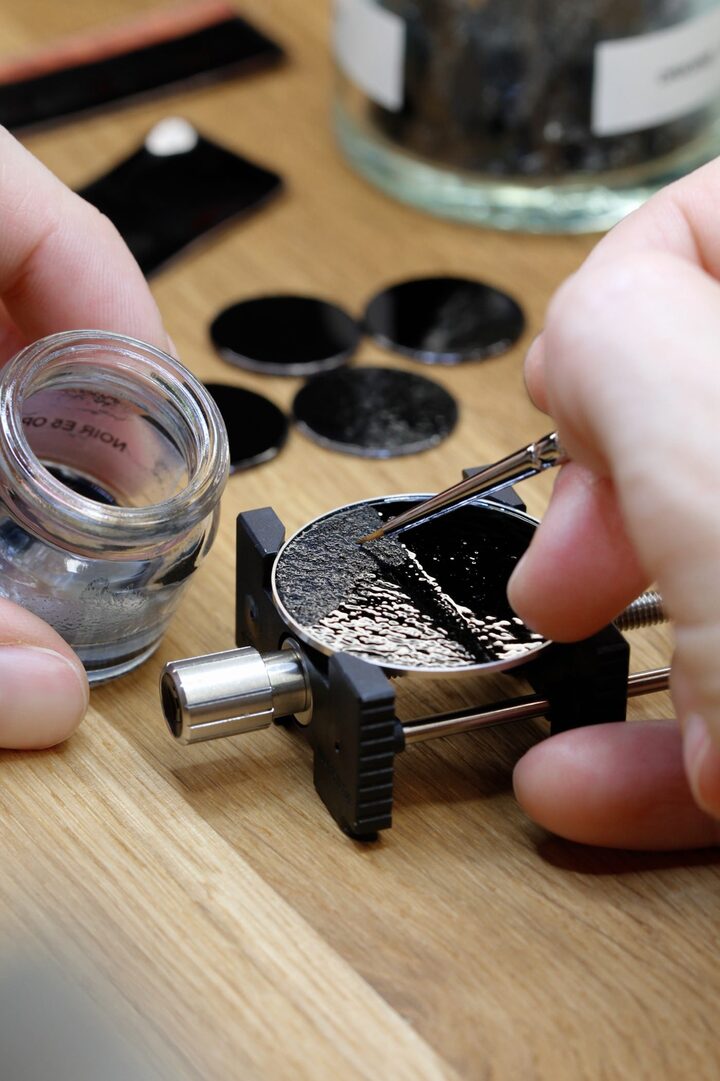 At the workshop, enamel is carefully applied before the piece is fired in the kiln.