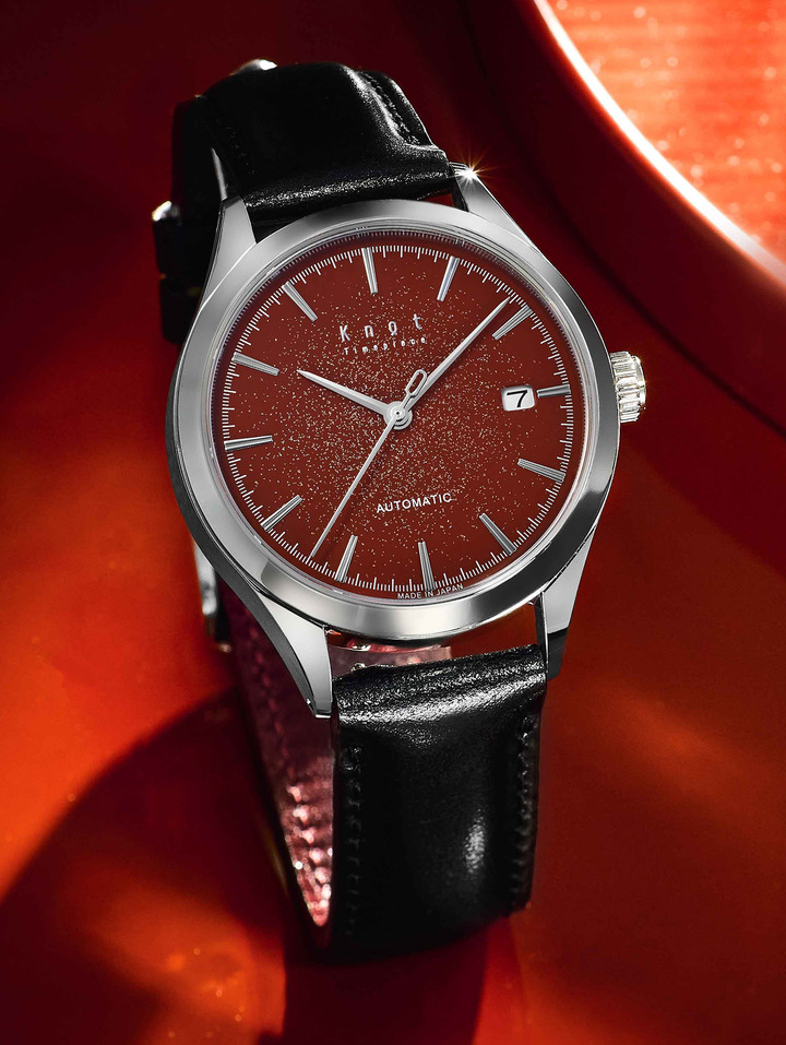 The traditionally vermilion red urushi dial sprinkled with gold and silver
