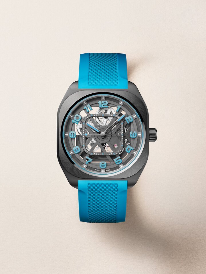 Hermès H08 Squelette blue version with a 39 mm cushion-shaped case in black DLC-treated titanium and a satin-finished ceramic bezel with mirror-polished bevels, openworked black dial, applied Arabic numerals in blue Super-LumiNova®, and hands coated in black PVD with blue Super-LumiNova®.